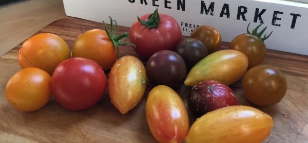 Erilaisia tomaatteja pöydällä.